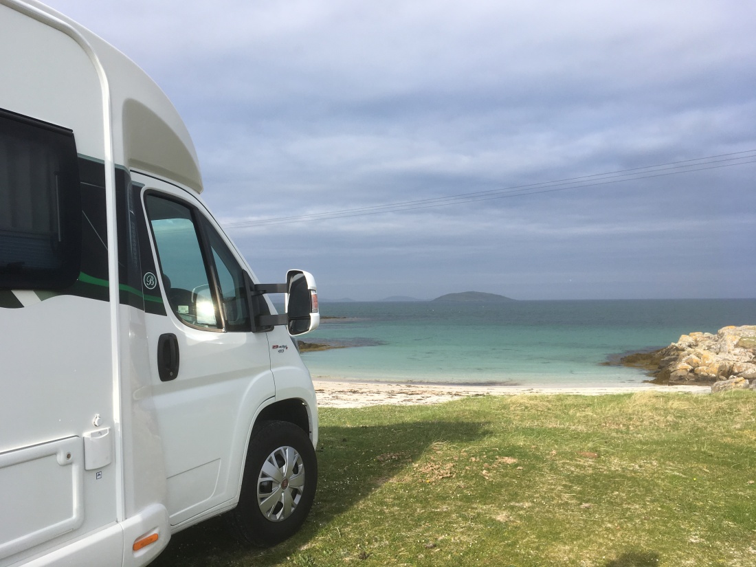 Motorhome parked next to a white sand beach on Eriskay with turquoise water